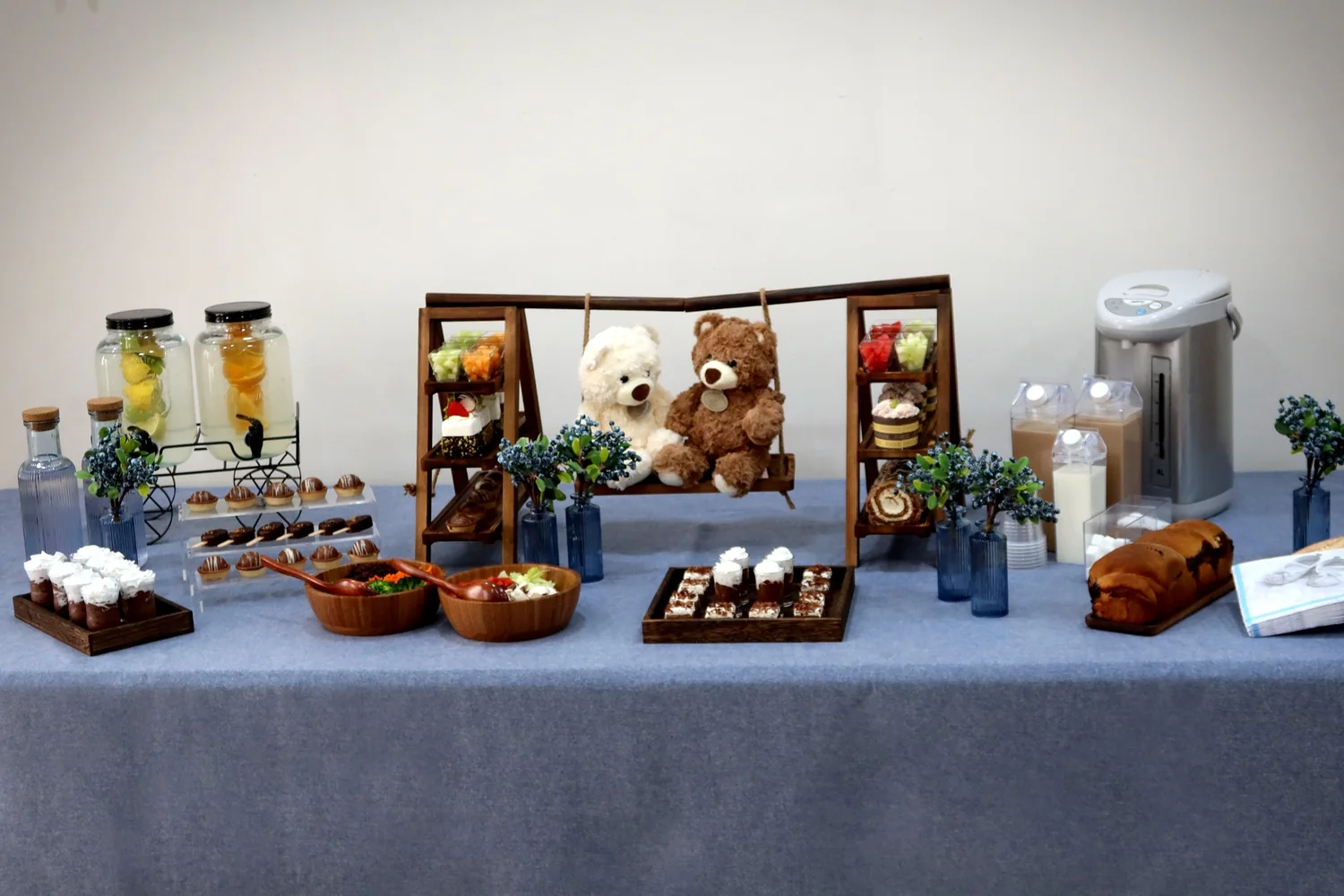 Blue buffet table with desserts, drinks and teddy bear centrepiece