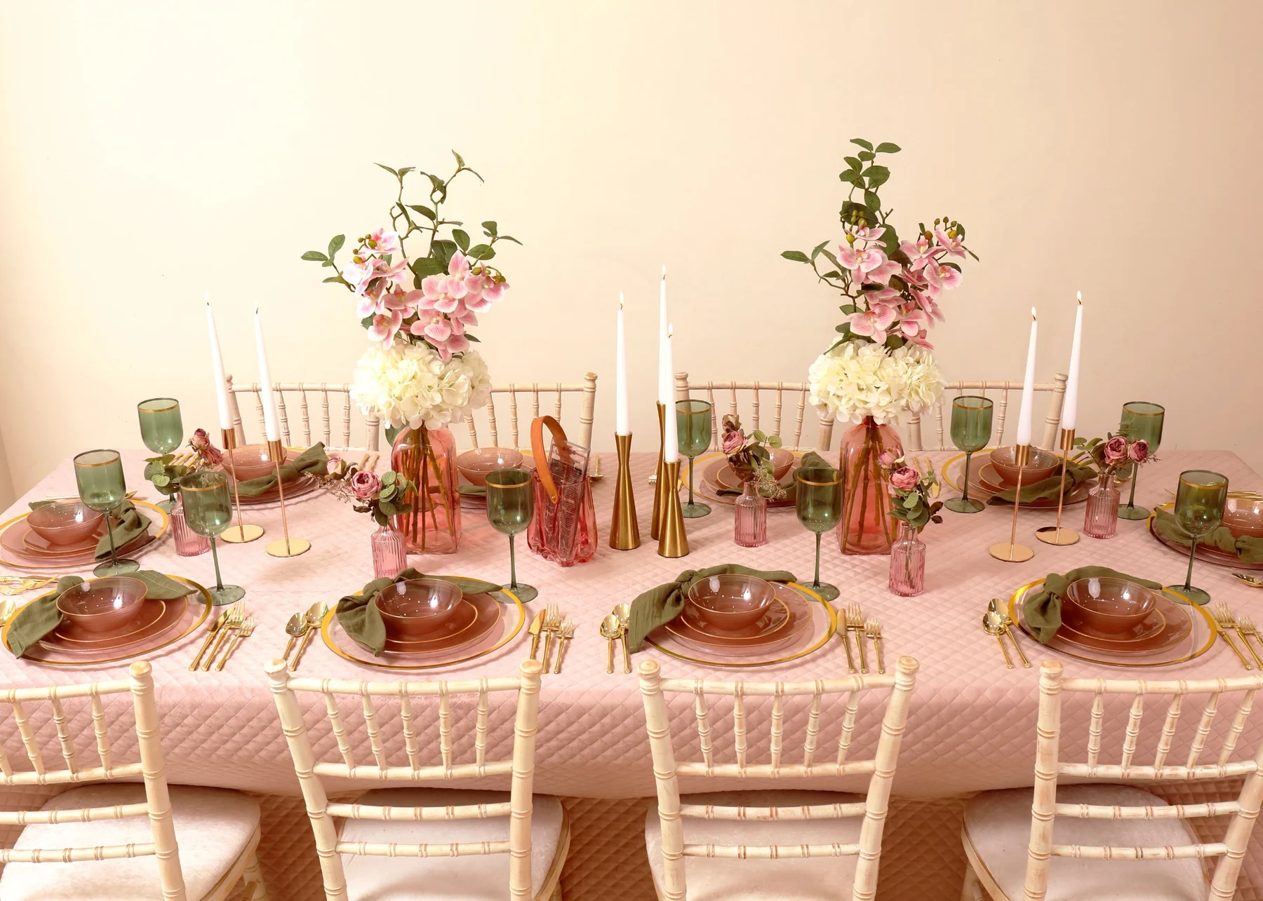 Blush pink and sage green tablescape with gold cutlery, candles and floral arrangements