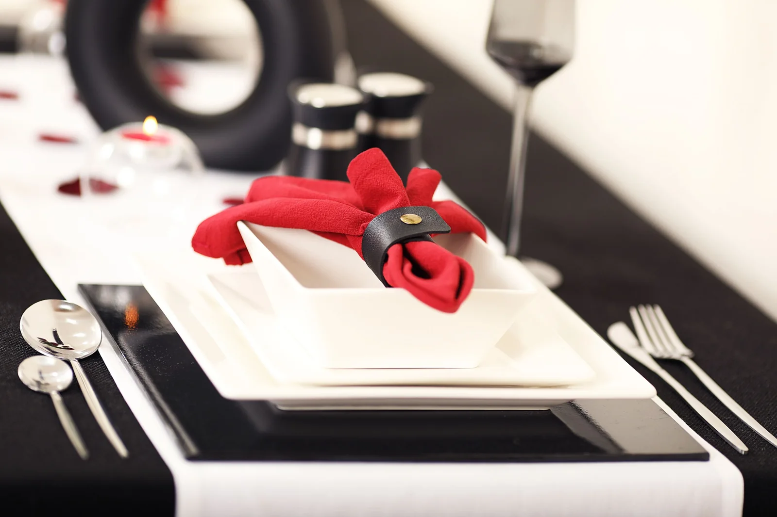 Close-up of a black, white and red place setting with a folded red napkin